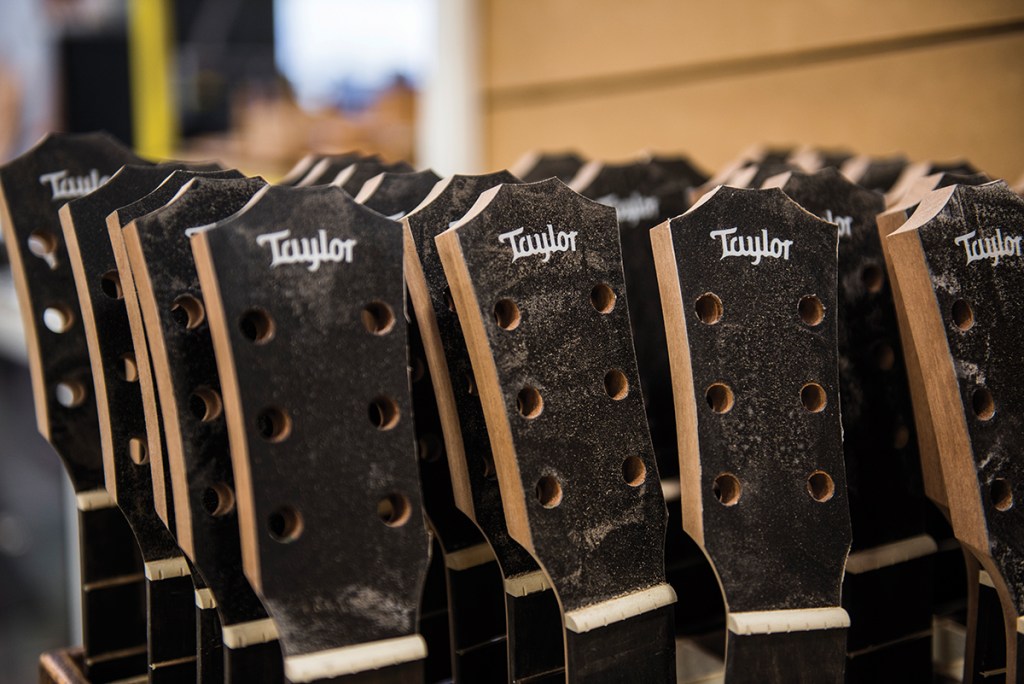 Several Taylor acoustic guitars sit in process at the Taylor factory.